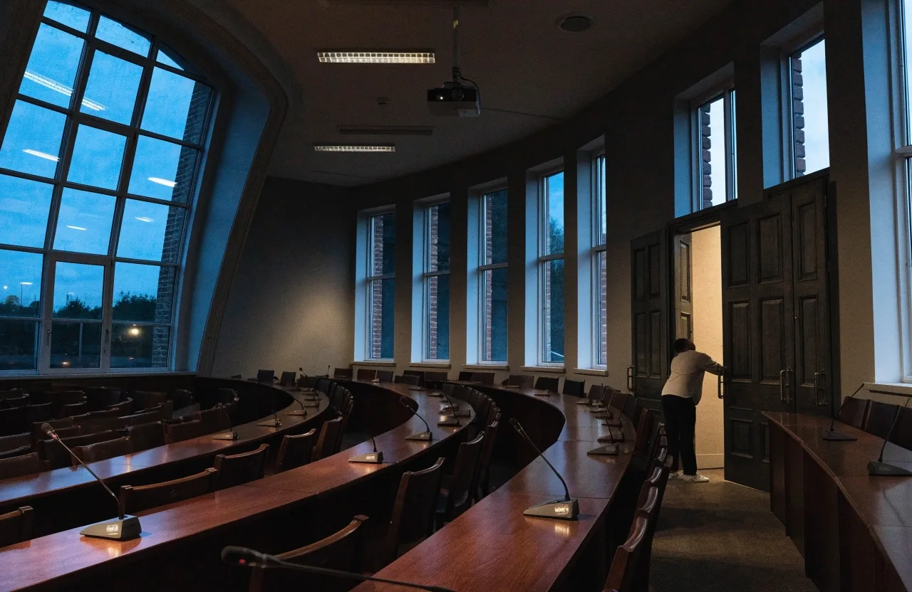 Ministeriumsflur in der Abenddämmerung mit einer Person und einer Aktentasche